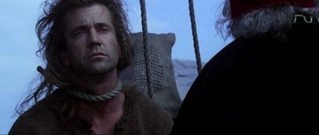 Movie still from “Braveheart” (1995), directed by Mel Gibson – A man sitting in a chair next to another man; Close Up shot, Low angle