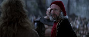 Movie still from “Braveheart” (1995), directed by Mel Gibson – A man with a beard wearing a red hat; Close Up shot, Over the shoulder angle