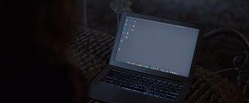 Movie still from “Brazen” (2022), directed by Monika Mitchell – A laptop computer sitting on top of a wooden table; Extreme Close Up shot, High angle