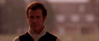 Movie still from “The Patriot” (2000), directed by Roland Emmerich – A man with a goatee is looking at the camera; Close Up shot, Over the shoulder angle