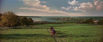 Movie still from “The Patriot” (2000), directed by Roland Emmerich – A couple of people riding a horse drawn carriage down a hill; Extreme Wide shot, High angle