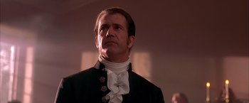 Movie still from “The Patriot” (2000), directed by Roland Emmerich – A man wearing a black and white suit and a white collar; Close Up shot, Low angle