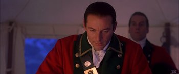 Movie still from “The Patriot” (2000), directed by Roland Emmerich – A man in a red jacket and a badge on his lapel; Close Up shot, Over the shoulder angle