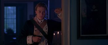 Movie still from “The Patriot” (2000), directed by Roland Emmerich – A man in a suit and tie standing in front of a window; Medium shot, Over the shoulder angle