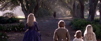 Movie still from “The Patriot” (2000), directed by Roland Emmerich – Two people walking down a dirt road with a horse; Wide shot, Over the shoulder angle