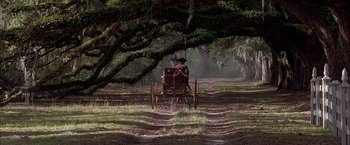 Movie still from “The Patriot” (2000), directed by Roland Emmerich – An old fashioned carriage traveling down a dirt road; Extreme Wide shot, High angle