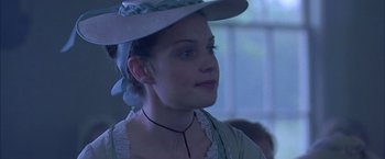 Movie still from “The Patriot” (2000), directed by Roland Emmerich – A young woman wearing a hat and a necklace; Close Up shot, Over the shoulder angle
