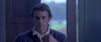 Movie still from “The Patriot” (2000), directed by Roland Emmerich – A young man is adjusting his neck tie while wearing a suit; Close Up shot, Over the shoulder angle
