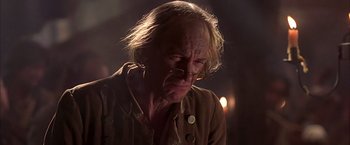 Movie still from “The Patriot” (2000), directed by Roland Emmerich – An old man with long blonde hair wearing a brown jacket; Close Up shot, Over the shoulder angle