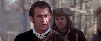 Movie still from “The Patriot” (2000), directed by Roland Emmerich – A man with a beard and a hat on; Close Up shot, Over the shoulder angle