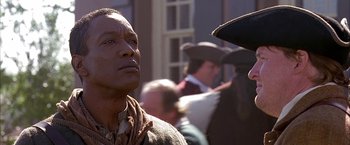 Movie still from “The Patriot” (2000), directed by Roland Emmerich – A man in a cowboy hat looking to his left; Close Up shot, Over the shoulder angle