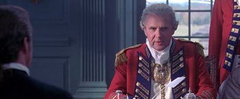 Movie still from “The Patriot” (2000), directed by Roland Emmerich – An older man in a red coat and gold medals; Close Up shot, Over the shoulder angle