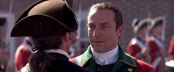 Movie still from “The Patriot” (2000), directed by Roland Emmerich – A man in a green jacket talking to another man in a black hat; Close Up shot, Over the shoulder angle