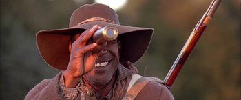 Movie still from “The Patriot” (2000), directed by Roland Emmerich – A man in a hat is looking through a telescope; Close Up shot, Over the shoulder angle