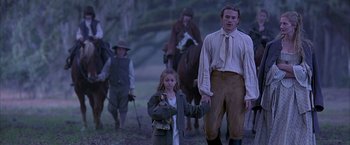 Movie still from “The Patriot” (2000), directed by Roland Emmerich – A group of people riding horses on a trail; Medium shot, Low angle