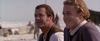 Movie still from “The Patriot” (2000), directed by Roland Emmerich – A man and a boy are standing next to each other on the beach; Close Up shot, Over the shoulder angle