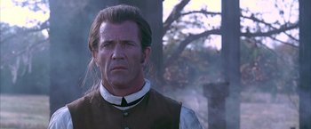 Movie still from “The Patriot” (2000), directed by Roland Emmerich – A person wearing a vest near a tree; Close Up shot, Low angle