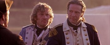 Movie still from “The Patriot” (2000), directed by Roland Emmerich – Two men dressed in military garb , one of which has a beard; Close Up shot, Over the shoulder angle