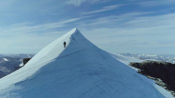 A person is standing on top of a snow covered hill