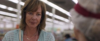 Movie still from “Breaking News in Yuba County” (2021), directed by Tate Taylor – A person wearing headphones in a store; Close Up shot, Over the shoulder angle