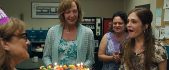 Movie still from “Breaking News in Yuba County” (2021), directed by Tate Taylor – Two women standing in front of a birthday cake; Medium shot, Over the shoulder angle