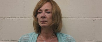 Movie still from “Breaking News in Yuba County” (2021), directed by Tate Taylor – An older woman wearing a blue shirt and a silver necklace; Close Up shot, High angle