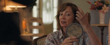 Movie still from “Breaking News in Yuba County” (2021), directed by Tate Taylor – A woman looking in the mirror while sitting on a chair; Close Up shot, Over the shoulder angle