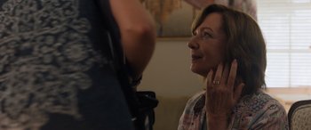 Movie still from “Breaking News in Yuba County” (2021), directed by Tate Taylor – A woman looking up at a man with a camera; Close Up shot, Over the shoulder angle