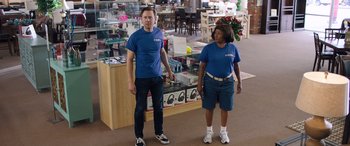 Movie still from “Breaking News in Yuba County” (2021), directed by Tate Taylor – A man and a woman standing next to each other in a store; Wide shot, Over the shoulder angle