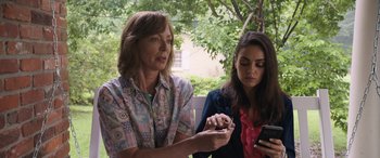 Movie still from “Breaking News in Yuba County” (2021), directed by Tate Taylor – Two women sitting next to each other on a bench; Medium shot, Low angle