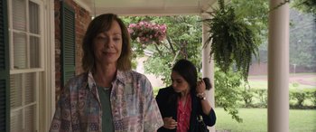 Movie still from “Breaking News in Yuba County” (2021), directed by Tate Taylor – A woman and a girl standing next to each other on a porch; Medium shot, Over the shoulder angle