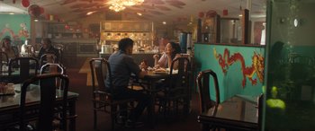 Movie still from “Breaking News in Yuba County” (2021), directed by Tate Taylor – A man and a woman are sitting at a table; Wide shot, Over the shoulder angle