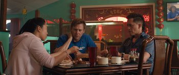Movie still from “Breaking News in Yuba County” (2021), directed by Tate Taylor – A group of people sitting at a table eating food; Medium shot, Over the shoulder angle