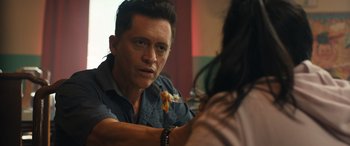 Movie still from “Breaking News in Yuba County” (2021), directed by Tate Taylor – A man sitting in front of a woman eating pizza; Close Up shot, Over the shoulder angle