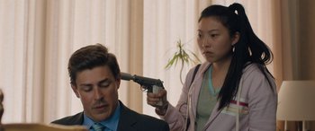Movie still from “Breaking News in Yuba County” (2021), directed by Tate Taylor – A woman holding a gun up above a man's head; Close Up shot, Over the shoulder angle