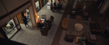 Movie still from “Breaking News in Yuba County” (2021), directed by Tate Taylor – An overhead view of an office area with furniture; Extreme Wide shot, High angle