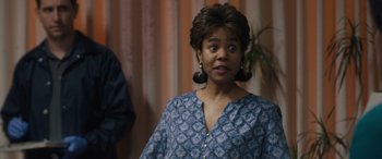 Movie still from “Breaking News in Yuba County” (2021), directed by Tate Taylor – A woman with a surprised look on her face standing in a room; Close Up shot, Over the shoulder angle