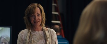 Movie still from “Breaking News in Yuba County” (2021), directed by Tate Taylor – A woman smiling for the camera in front of a ladder; Close Up shot, Over the shoulder angle