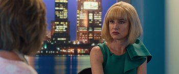 Movie still from “Breaking News in Yuba County” (2021), directed by Tate Taylor – A woman sitting in front of a city skyline at night; Close Up shot, Over the shoulder angle
