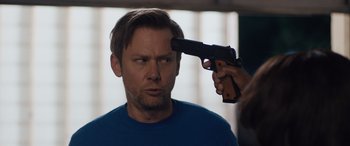 Movie still from “Breaking News in Yuba County” (2021), directed by Tate Taylor – A man with a gun pointed at his face; Close Up shot, Over the shoulder angle