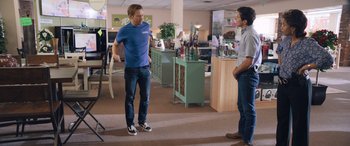 Movie still from “Breaking News in Yuba County” (2021), directed by Tate Taylor – Two men standing in a room talking to each other; Wide shot, Over the shoulder angle