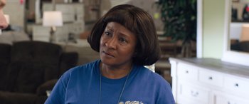 Movie still from “Breaking News in Yuba County” (2021), directed by Tate Taylor – An older woman wearing a blue t - shirt and a necklace; Close Up shot, Over the shoulder angle