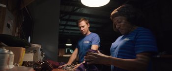 Movie still from “Breaking News in Yuba County” (2021), directed by Tate Taylor – A man and a woman working together on a project; Medium shot, Low angle