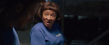 Movie still from “Breaking News in Yuba County” (2021), directed by Tate Taylor – An older woman wearing a t - shirt and looking at the camera; Close Up shot, Over the shoulder angle