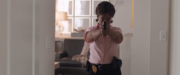 A woman holding a gun in a room