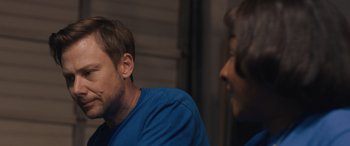 Movie still from “Breaking News in Yuba County” (2021), directed by Tate Taylor – A man and a woman sitting next to each other in a room; Close Up shot, Over the shoulder angle