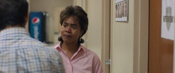 Movie still from “Breaking News in Yuba County” (2021), directed by Tate Taylor – A woman in a pink shirt is standing in a room; Close Up shot, Over the shoulder angle