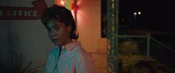 Movie still from “Breaking News in Yuba County” (2021), directed by Tate Taylor – A woman standing in front of a building at night; Close Up shot, Over the shoulder angle