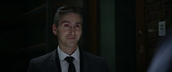 Movie still from “Broken” (2021), directed by Patrick Phillips – A person wearing a suit and tie; Close Up shot, Over the shoulder angle