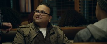 Movie still from “Broken” (2021), directed by Patrick Phillips – A man sitting in front of a window with glasses on; Close Up shot, Over the shoulder angle